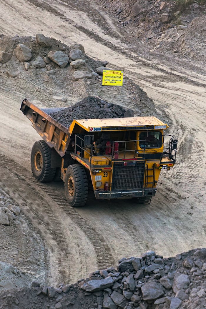 about-01 Heavy mining truck transporting minerals in a rocky open-pit quarry in Bahula, West Bengal.